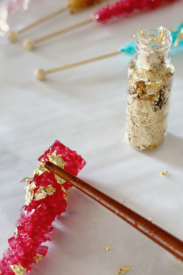 Transform rock candy into gem-inspired jewelry for a "She's a Gem" party using edible gold leaf.