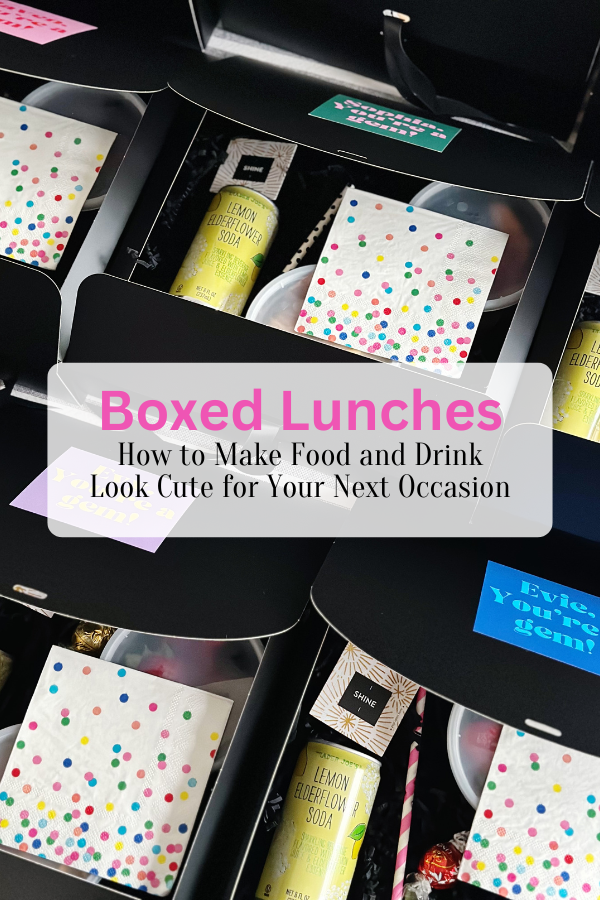 A collection of black boxed lunches, each thoughtfully packed with a can of lemon elderflower soda, colorful polka dot napkins, a “shine” fortune card, and topped with custom stickers featuring fun phrases like “You’re a gem!” The boxes are tied with black ribbon for a polished, coordinated look, perfect for a themed event. Text overlay reads "Boxed Lunches | How to Make Food and Drink Look Cute for Your Next Occasion".