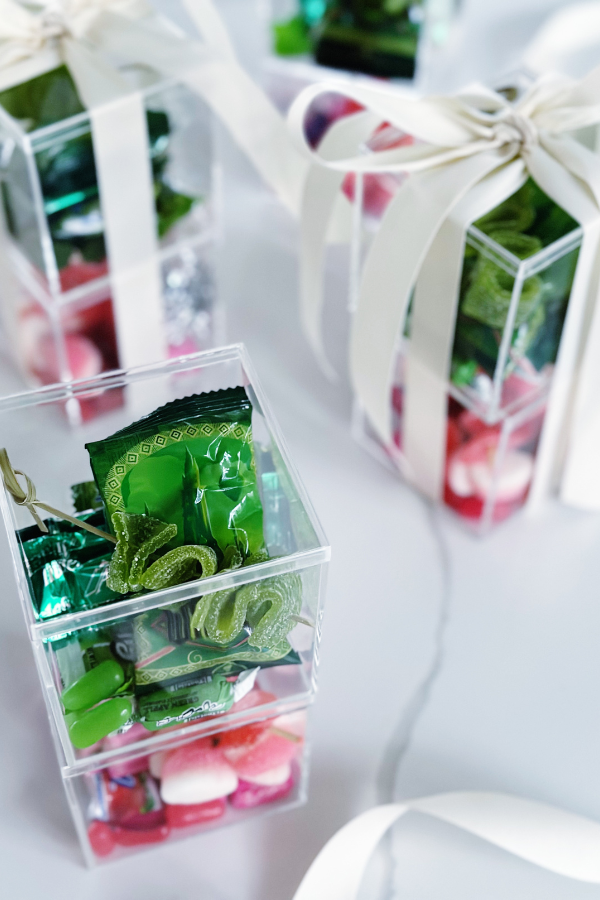 Candy boutique DIY gift idea featuring acrylic boxes filled with color-coordinated candies, perfect for matching any party theme.